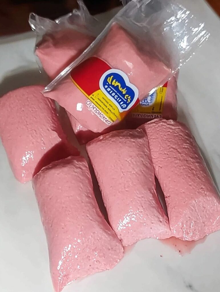 Hielitos de Danonino caseros, cremosos y de color rosa, sobre una superficie blanca.
