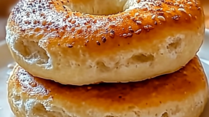 Homemade fluffy cottage cheese almond flour bagels on a wooden board with cream cheese and herbs