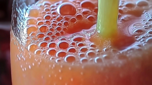 Batido morado de arándanos y espinacas en un vaso alto con ingredientes frescos alrededor