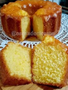 Bizcocho clásico esponjoso de color dorado, con corte limpio que muestra su interior húmedo y bien cocido, sobre un plato decorativo blanco.