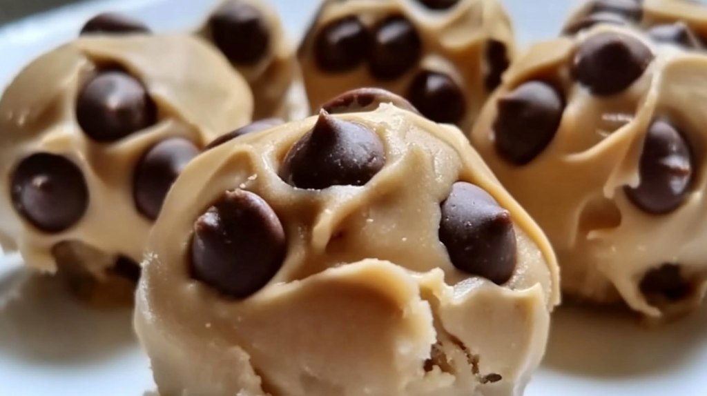 Frozen Greek yogurt peanut butter bites with mini chocolate chips arranged on white plate, healthy protein-rich frozen dessert