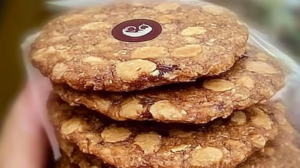 Galletas de avena doradas y crujientes hechas con harina de avena casera, servidas en un plato blanco sobre mesa de madera rústica