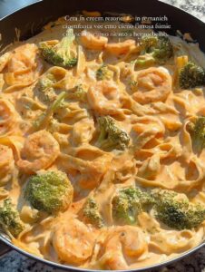 Fettuccini en salsa cremosa de chipotle con camarones y brócoli, servido en sartén.