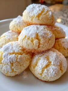 Polvorones de maicena con limón sin gluten servidos sobre un plato de cerámica blanca, decorados con ralladura de limón.