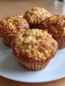 Muffins saludables de avena y plátano recién horneados, esponjosos y sin azúcar refinada.