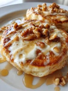 Panqueques de zanahoria y nuez con yogur griego servidos con miel y nueces encima