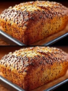 Pan de avena casero recién horneado con semillas de lino sobre la corteza.