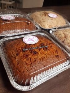 Pan de zanahoria casero en moldes de aluminio con tapa transparente, listo para vender o regalar.