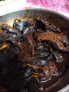 Plato tradicional de mole casero con piezas de pollo en una salsa espesa y oscura