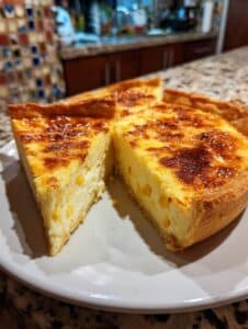 Pay de elote cremoso recién horneado con base dorada y relleno esponjoso.