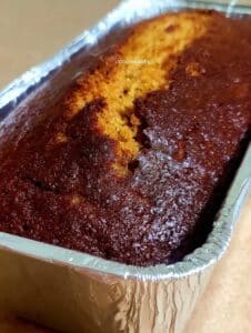 Pan de elote natural sin harina horneado en molde de aluminio, con costra dorada y textura húmeda