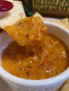 Salsa de piña con chile de árbol servida en un ramekin blanco, acompañada de totopos crujientes.